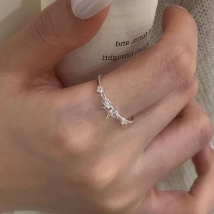 Gros plan d'une bague nœud en argent 925 avec zircons portée sur l'index de la main