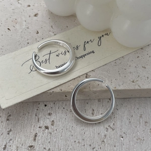 Close-up of minimalist S925 silver open rings on a textured stone plate with cards