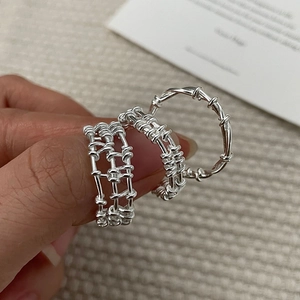 Detail of S925 silver layered grid rings featuring woven textures on hand model
