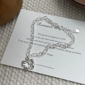 Detail of 925 sterling silver handmade flower bracelet with S925 heart tag on white card