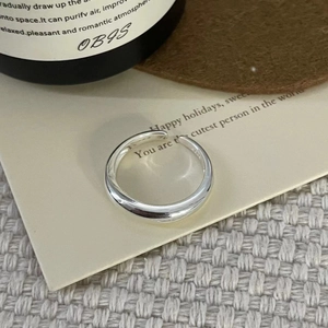 Close-up of polished S925 sterling silver open ring on minimalist aesthetic background