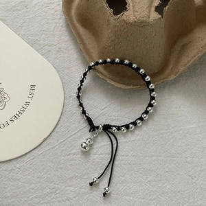 Detail of S925 sterling silver gourd pendant on black woven bracelet with silver beads