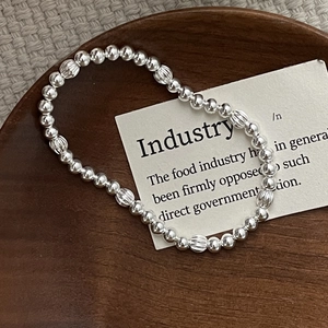 Close-up of S925 sterling silver beaded bracelet with striped beads on wooden tray