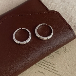 Polished S925 sterling silver minimalist open ring on a luxury leather pouch background