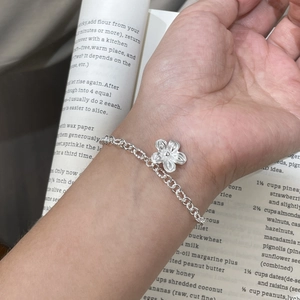 Handcrafted S925 sterling silver flower bracelet for women on an aesthetic book background