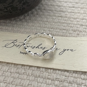 Macro detail of S925 sterling silver pig nose ring with white chalcedony on knit fabric