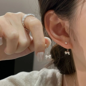 Elegant S925 sterling silver bow earrings and multi-layer zircon ring on a female model