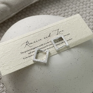 Macro di orecchini a cerchio quadrati in argento con finitura glitterata su carta