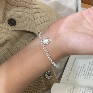Detailed view of a handmade 925 silver flower bracelet worn on a female wrist