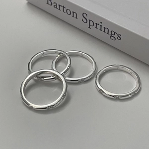 Detail of four slim silver stackable rings with sparkling cubic zirconia inlays