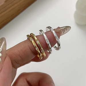 Macro shot of minimalist gold and silver stacked rings featuring dainty inset cubic zirconia