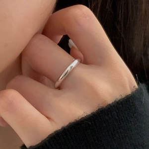 Close-up of minimalist S925 sterling silver smooth round ring on a model's finger