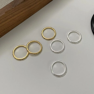 Macro shot of minimalist S925 sterling silver and gold rings with textured accents