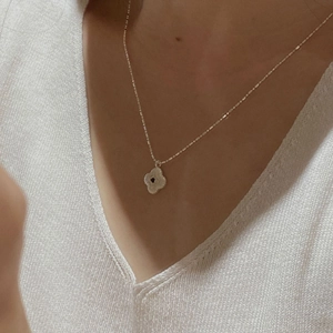 Close-up of S925 silver four-leaf clover pendant with black stone on a neck chain