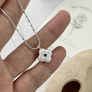 Detail of S925 silver four-leaf clover necklace with black zircon on hand