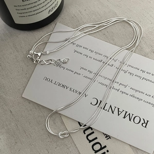 Detail of S925 silver double-layered snake chain with knot design and heart charm