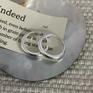 Close-up of polished S925 sterling silver hoop earrings with clear hallmark engraving