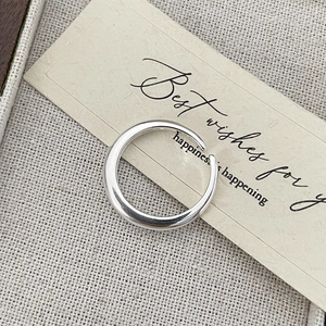 Close-up of minimalist S925 sterling silver adjustable open ring on textured surface