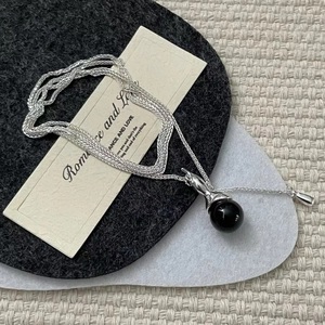 S925 sterling silver necklace featuring a glossy black round bead pendant on silver chain