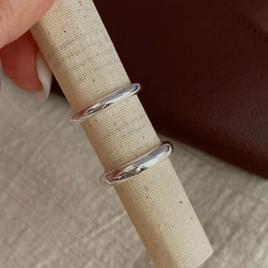 Close-up of dual high-polished S925 sterling silver minimalist rings on linen display