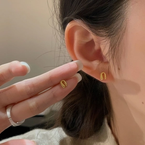 Minimalist S925 sterling silver golden U-shaped stud earrings worn by a model