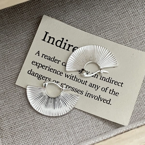 Macro detail of S925 sterling silver fan-shaped hoop earrings with vertical ribbed texture