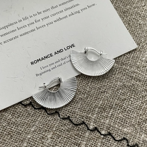 Macro shot of S925 sterling silver fan shaped hoop earrings with textured radial pleats
