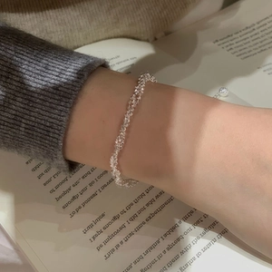 Detail of shimmering S925 sterling silver multi-layered chain bracelet on model wrist