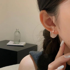 Close-up of S925 sterling silver fan-shaped earring worn on model for elegant style