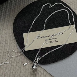 Detail of S925 silver necklace with minimalist clear crystal sphere on black felt background