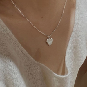 Minimalist S925 sterling silver heart pendant necklace on model with polished finish