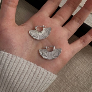 Detail of S925 sterling silver fan-shaped hoop earring with fine radial texture