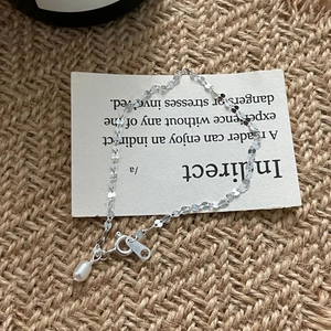Gros plan du bracelet en argent S925 à paillettes avec une perle d'eau douce en goutte
