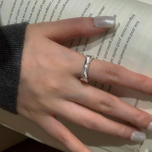 Detail shot of a matte twisted silver ring with lava texture on a finger