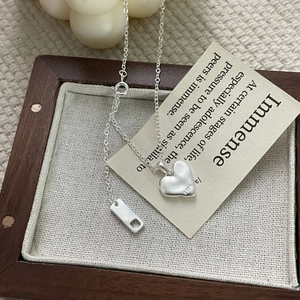 Detailed macro view of S925 sterling silver heart pendant with hallmark in a jewelry tray