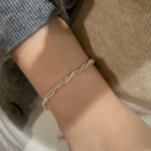Detail of shimmering S925 sterling silver twisted bracelet worn on a woman's wrist
