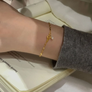 Détail du bracelet en argent S925 doré avec perle d'eau douce et sequins sur le poignet