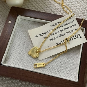 Macro view of gold S925 sterling silver heart pendant and engraved AG925 hallmark tag