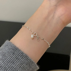 Bracelet élégant en argent sterling S925 avec perle d'eau douce sur poignet féminin