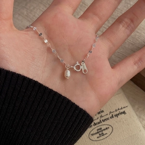 Détail macro d'une chaîne en argent S925 avec perle d'eau douce et poinçon