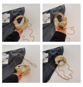 Detailansicht der goldfarbenen Abendtasche mit Strukturgriff und feiner Metallschulterkette