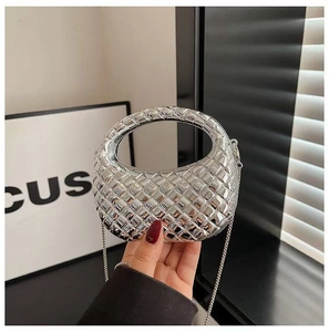 Détail d'un mini sac à main tissé argenté avec poignée intégrée et bandoulière chaîne