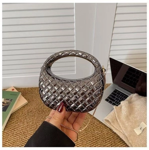 Détail du sac tressé argenté montrant la texture métallique et la chaîne dorée