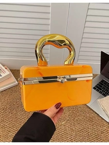 Detalle del bolso caja de acrílico mármol naranja con asa dorada y correa de cadena