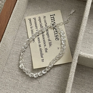 Detailed close-up of S925 sterling silver woven bracelet with lobster clasp and tag