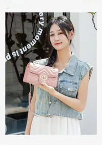 Close-up of pink quilted faux leather crossbody bag with golden chain and metal lock
