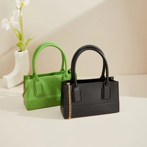 Detailed view of PVC square jelly bags in green and black with gold metal chain straps