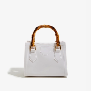Detailed view of the white square jelly bag with vintage dark brown bamboo handle