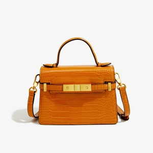Détail du sac en cuir orange à texture crocodile avec serrure dorée élégante en métal