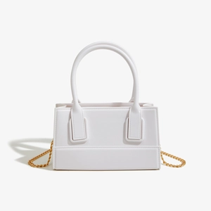 Detail view of white PVC jelly bag with golden chain strap and round top handles